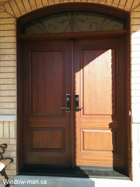 Fiberglass door. Stained. Double front entry. Wrought iron glass round top arch head transom. Multipoint locks